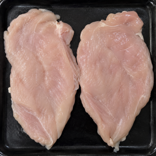 Illustrative image of raw chicken steaks on a black butcher’s tray