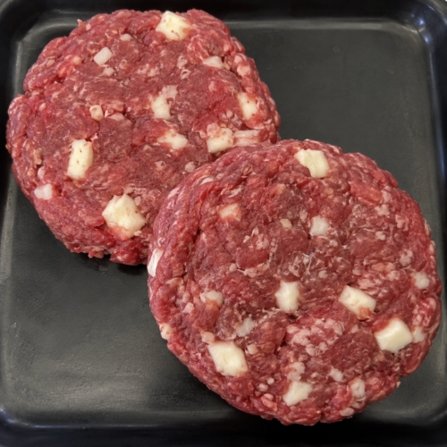 Illustrative image of raw mozzarella burgers on a black butcher’s tray