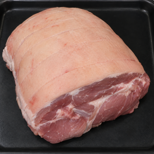 Illustrative image of raw pork leg joint on a black butcher’s tray