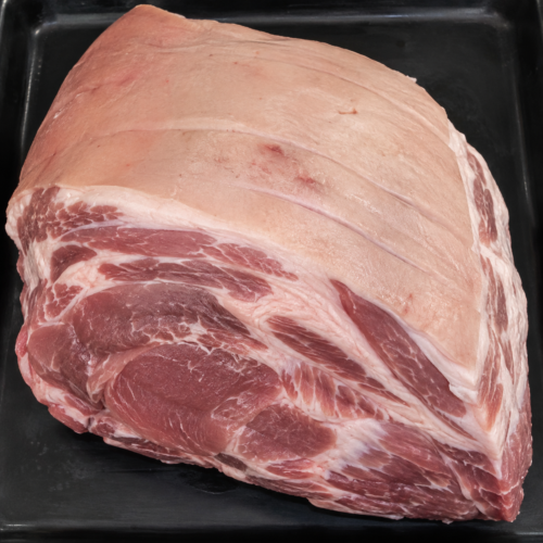 Illustrative image of raw pork shoulder joint on a black butcher’s tray