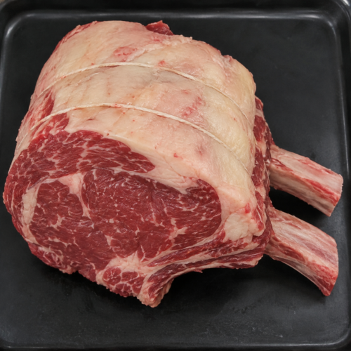 Illustrative image of raw rib of beef on a black butcher’s tray